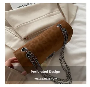 Detail of brown leopard print texture and metal chain strap on a stylish small square bag