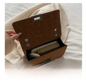 Close-up showing the spacious leopard print interior of this brown suede chain handbag