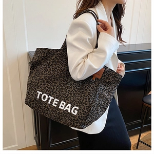 Detail of leopard print canvas tote bag with TOTE BAG lettering and sturdy handles