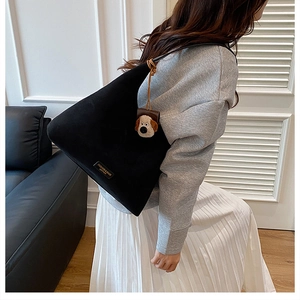 Détail du sac cabas noir avec étiquette vintage et breloque chiot en peluche marron