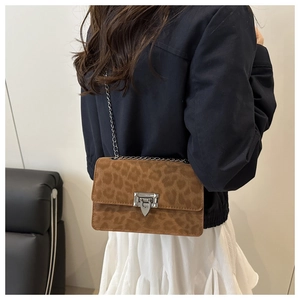 Detail of trendy leopard print crossbody bag with silver square clasp and metal chain