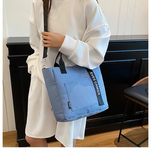 Blue canvas lunch bag with adjustable shoulder strap and large front pocket for office workers