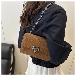 Detailed view of leopard print crossbody bag with silver chain strap and metal lock