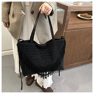 Detail of black large woven tote bag with fringe tassels and leopard print pattern