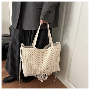 Detail of bohemian cream tote bag with hand-knotted fringe and crochet texture
