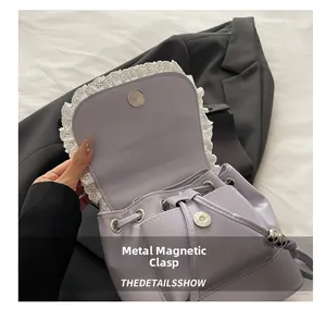 Detail of light purple bag with white lace trim and metal magnetic snap closure