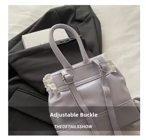 Detailed view of lilac backpack featuring white lace trim and adjustable metal buckles