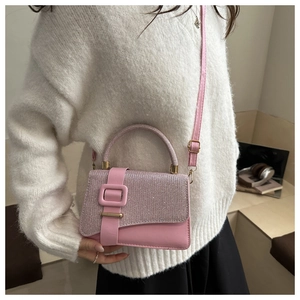Detail of pink glitter and leather crossbody bag with square buckle and top handle