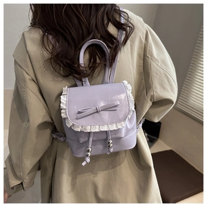 Rear view of a model wearing the lavender backpack with lace trim and bow detail