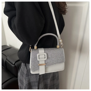 Detailed side view of white faux leather crossbody bag with silver sequins and diamond strap