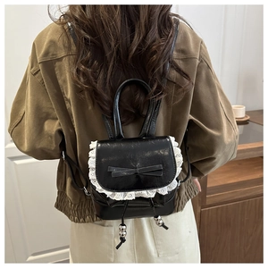Detail of black backpack with elegant white lace trim and bowknot decoration