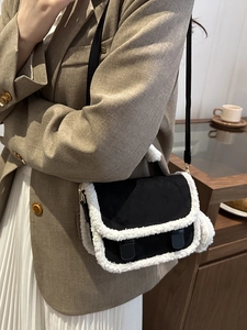 Chic black suede crossbody bag with plush white faux shearling trim and leather strap