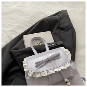Detail of lavender backpack with sweet lace trim, bow decoration and silver bead drawstring