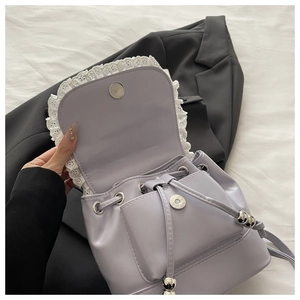 Detail of lavender PU mini backpack with lace trim and magnetic drawstring closure