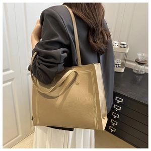 Detail of khaki tote bag with lychee pattern faux leather and decorative stitching
