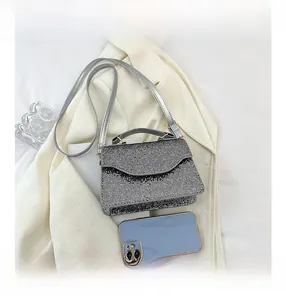 Detail of silver rhinestone evening bag showing size comparison with a smartphone