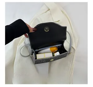 Detail shot showing internal capacity of the sparkling evening bag with phone and lipstick