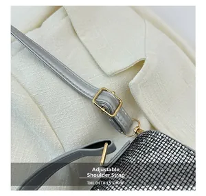 Detail of adjustable leather strap with gold buckle on a silver rhinestone evening bag