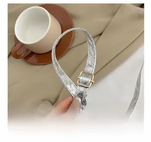 Detail of adjustable silver leather strap with premium gold buckle for evening bag