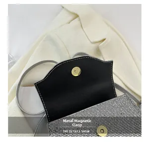 Detail shot of the golden magnetic snap and shiny silver sequins on a luxury evening bag