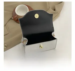 Interior view of small silver evening clutch with black lining and gold magnetic closure