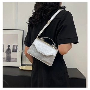 Silver metallic pleated evening clutch with chain strap shown in crossbody style on model