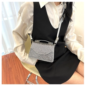 Detail shot of the silver sequin evening bag featuring a metallic adjustable strap