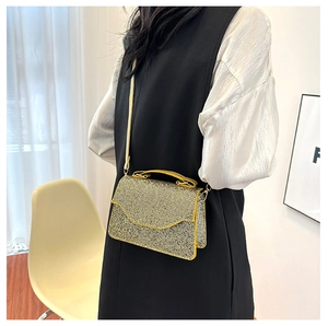 Model showcasing a rectangular rhinestone handbag with top handle and silver strap
