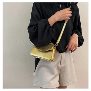 Detail of luxury gold metallic clutch with chain strap on shoulder for party