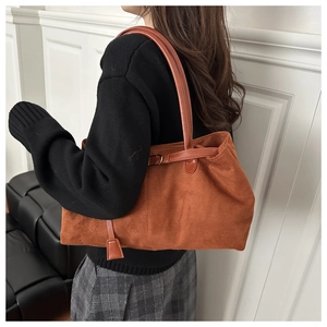 Caramel brown suede tote bag detail showing minimal design and shoulder strap styling