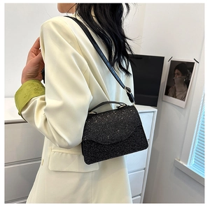 Detail of elegant black sequin evening bag with glitter texture and chic flap design