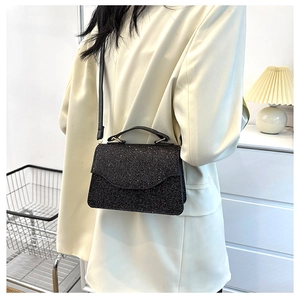 Detail of a chic black sequin handbag with a slim shoulder strap for party wear