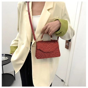 Detail of red sequin handbag with gold hardware and detachable strap for evening parties