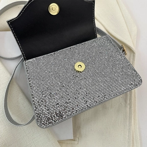 Detail of silver rhinestone evening bag showing magnetic closure and black lining