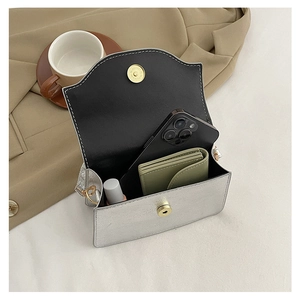 Internal view of silver clutch showing space for a phone, wallet, and cosmetics