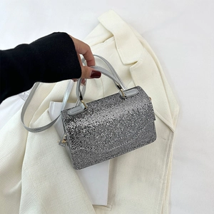 Macro shot of silver crystal clutch showing sparkling diamond texture and gold hardware