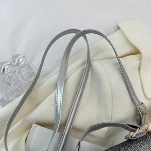 Detail of silver strap with gold metal buckle on a black mesh bag with glitter
