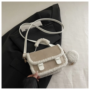 Detail view of khaki faux suede crossbody bag with white shearling trim and mini round pouch