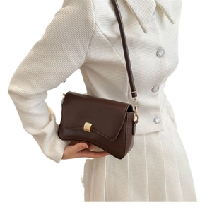 Elegant dark brown faux leather baguette bag with gold buckle on a tweed suit model