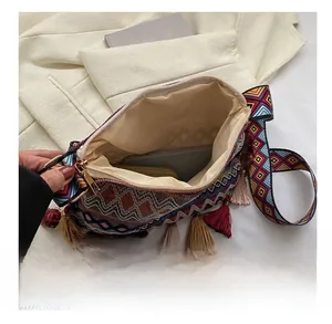 Detail view of ethnic crossbody bucket bag interior capacity with colorful fringe accents