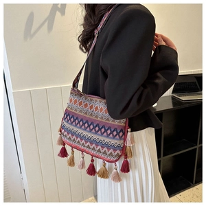 Close-up of ethnic style bucket bag with colorful geometric patterns and long tassels