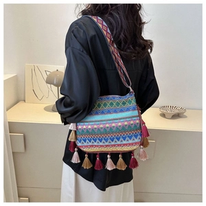 Close-up of bohemian woven bucket bag with colorful geometric patterns and fringe
