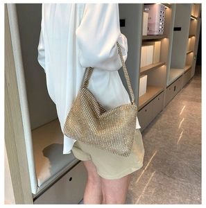 Detailansicht der dichten goldenen Strasssteine und des metallischen Glanzes der Handtasche