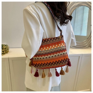 Detailed close-up of bohemian woven bucket bag with vibrant geometric patterns and tassels