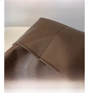 Macro shot of brown pebble grain faux leather surface with fine stitching details