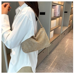Nahaufnahme der goldenen Strass-Schultertasche mit Metallkette auf der Modellschulter