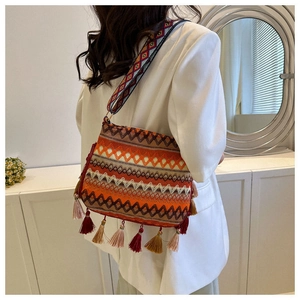 Detail of bohemian bucket bag with colorful jacquard weave and long tassel fringe