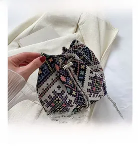 Detail view of ethnic jacquard bucket bag with woven geometric patterns and silver chain