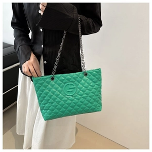 Detail of green quilted tote bag with silver chain strap and circular embossed logo