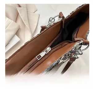 Close-up of the smooth silver metal zipper and brown leather trim on the ethnic tote bag